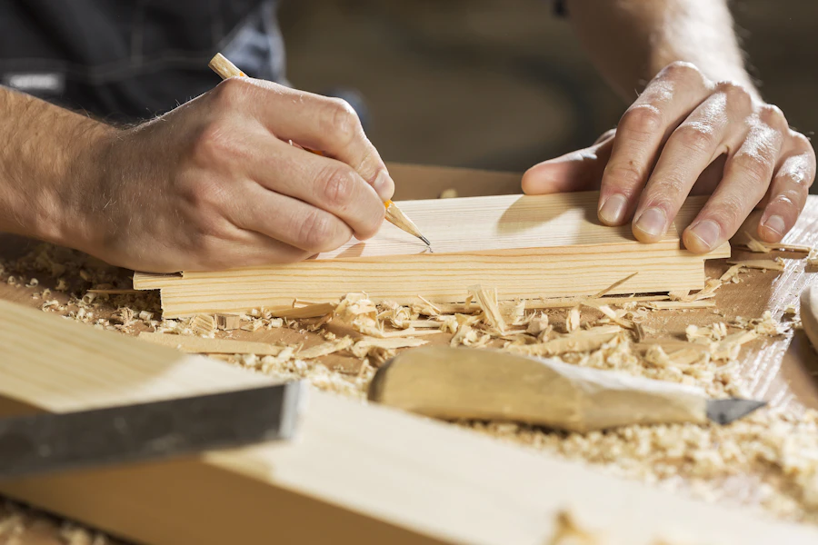 Tischler zeichnet auf Holz an
